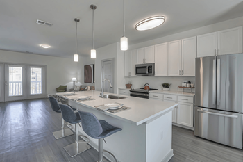 A modern kitchen with white cabinets and a large island.